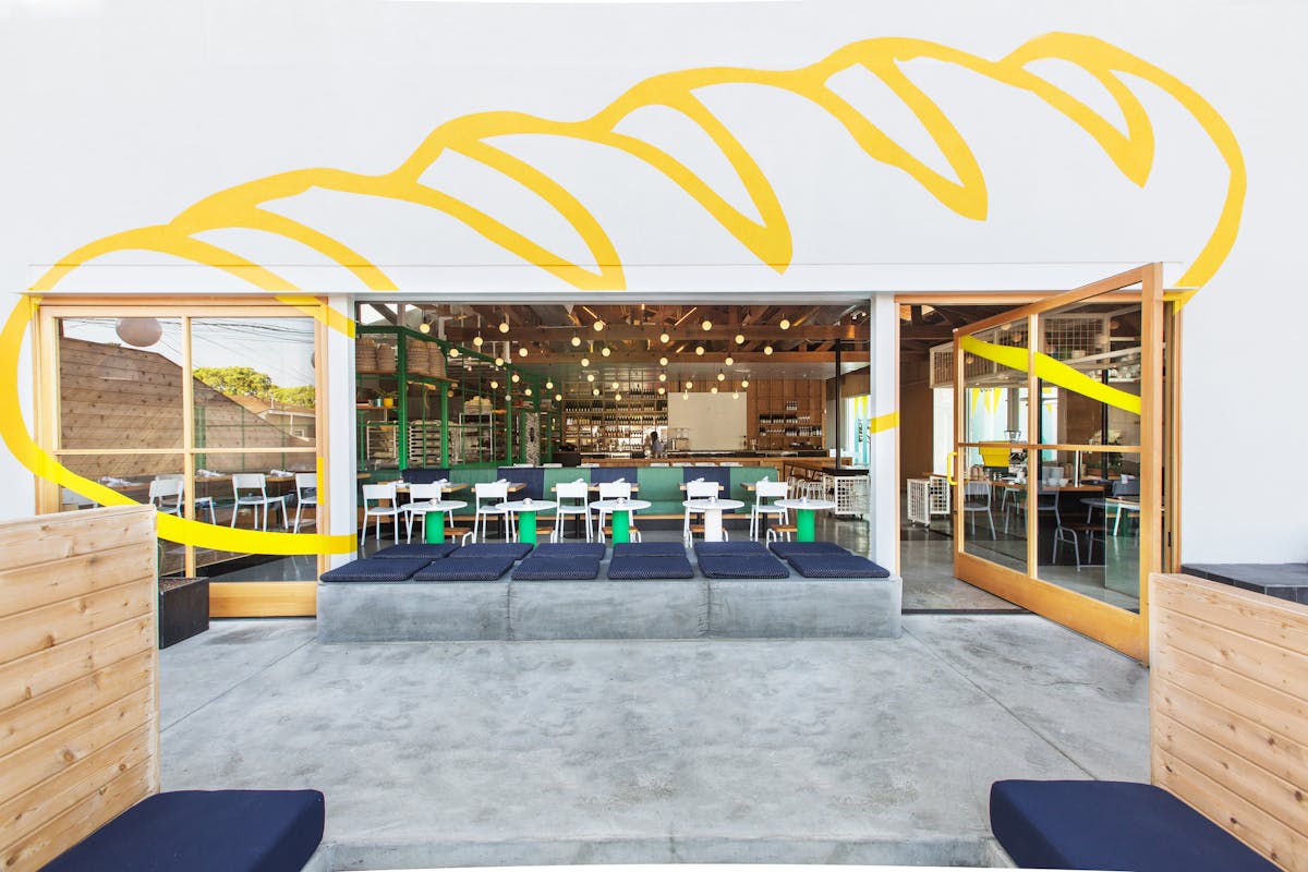 a yellow bench sitting on top of a bed